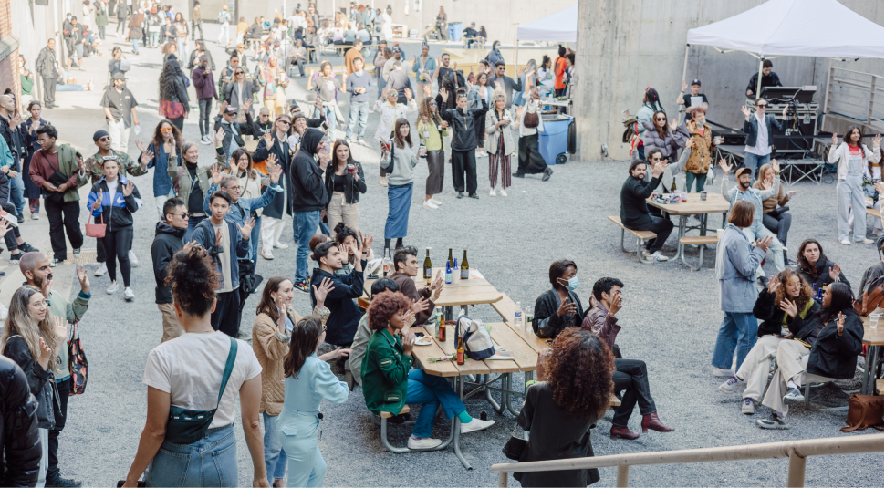 A large crowd of people sitting and standing, and holding their handing sup
