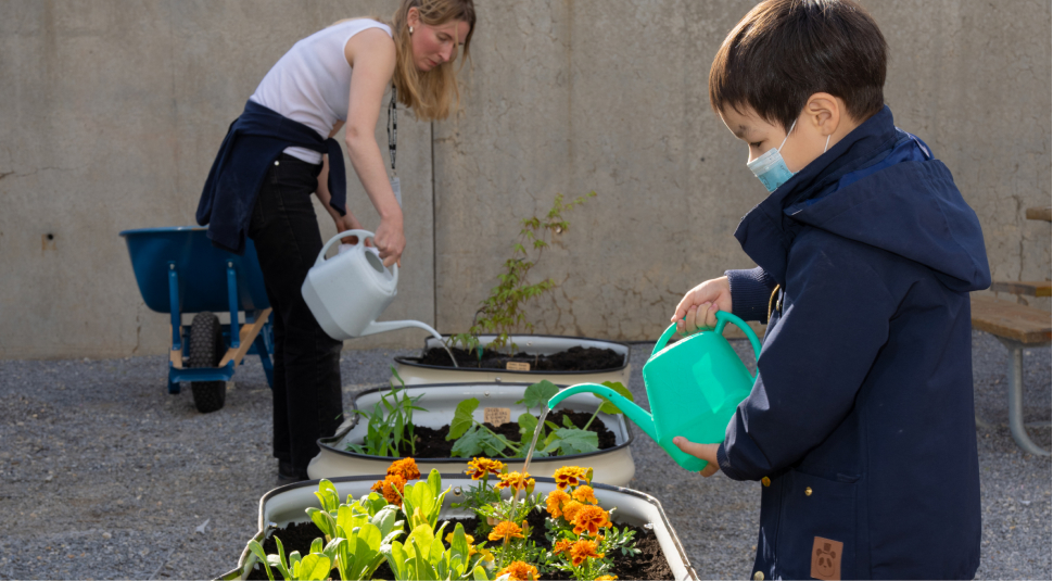 A person and a child watering plants.