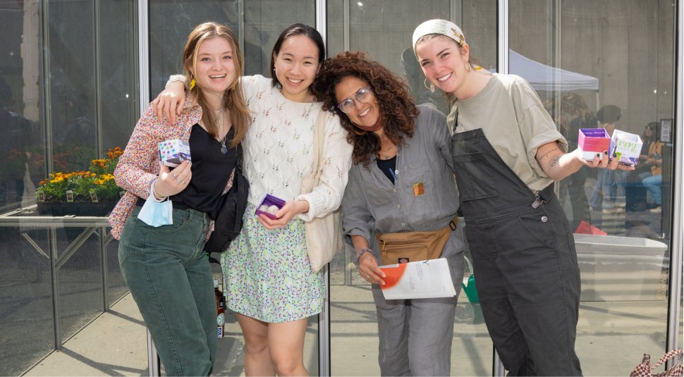 Four people posing and smiling at the camera.