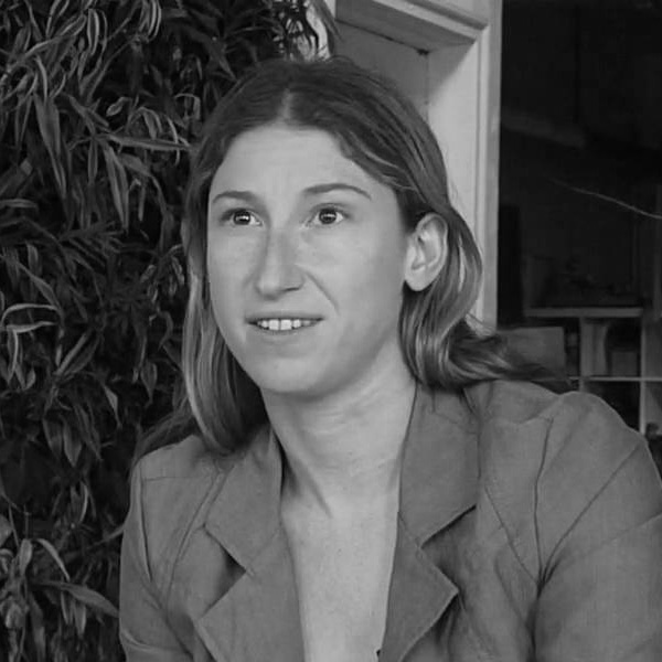 Marni Majorelle, A black and white image of a white woman with long light hair. She is smiling and is wearing a casual blazer.