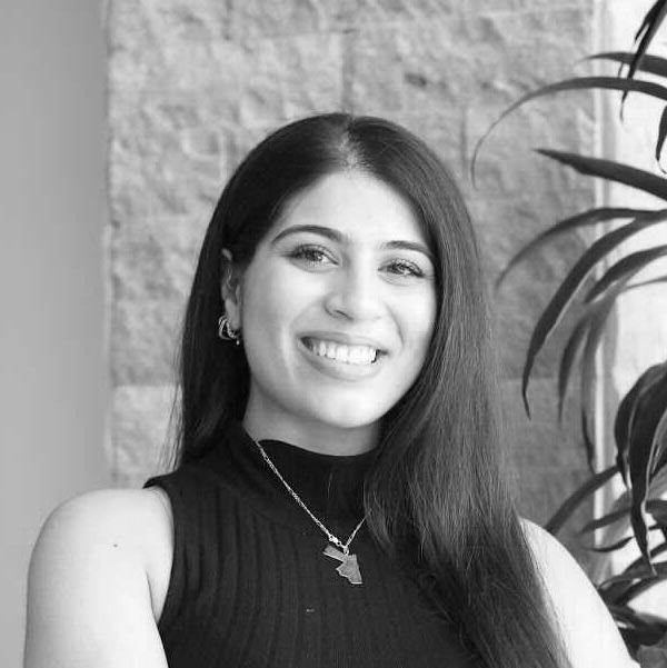 Nicole Nimri, A smiling Jordanian woman with long dark hair and a sleeveless, black turtleneck.