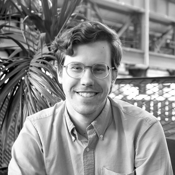 Ross McBee, a white man with glasses in a button-down shirt, smiling